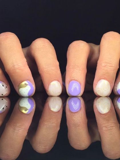 A playful abstract design with purple and white polish, accented with gold foil and black dots.