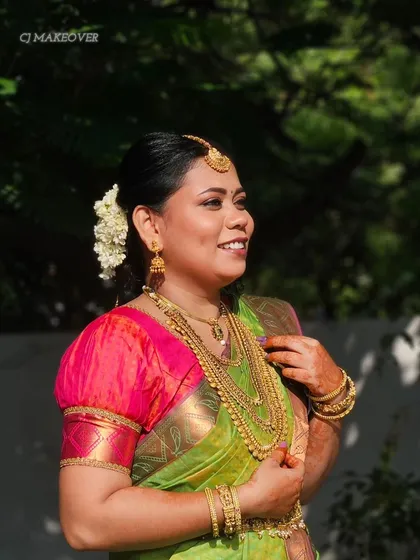 A happy bride in a green and pink Kanjivaram saree. Her makeup is radiant and her smile says it all.