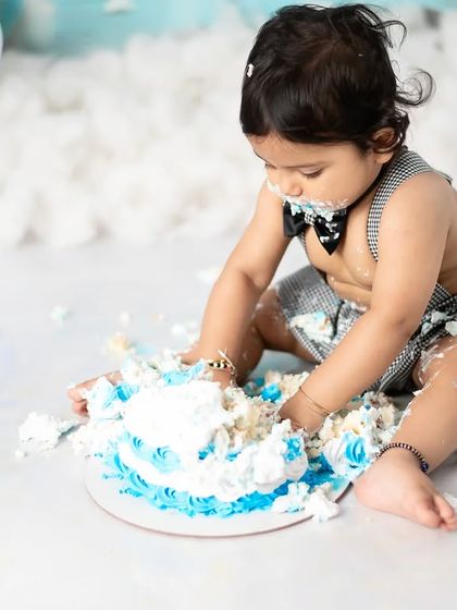 The aftermath of a successful cake smash. This photo captures the pure, sticky joy of a baby enjoying their first taste of birthday cake.