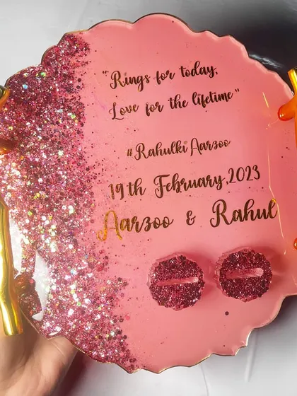 For those who love sparkle, this pink glitter ring platter is a showstopper. The design features a cascade of pink glitter, gold branch handles, and matching glittery ring holders.