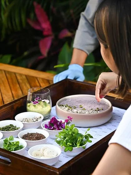 A guest participates in a "Farm to Table" experience, creating their own dish with fresh, sustainable ingredients. This highlights our commitment to interactive and eco-conscious dining.