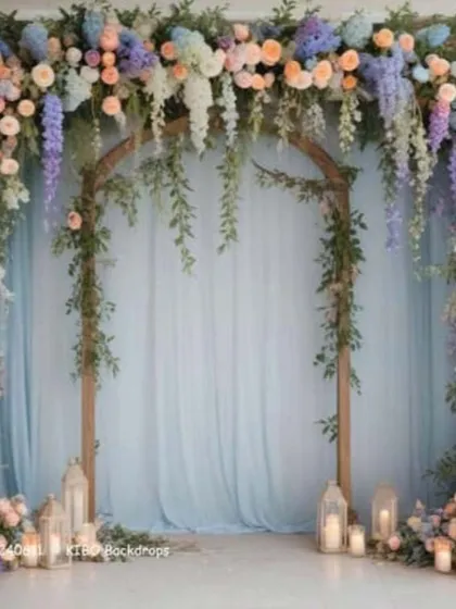 This is an example of a simple and elegant floral archway. The design uses pastel flowers and hanging greenery over a wooden frame, perfect for a photo booth or entrance decor.