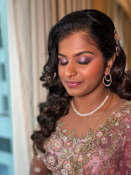 The complete look for Akshaya, with soft curls framing her face. The makeup and hair work together to create a cohesive and romantic reception style.