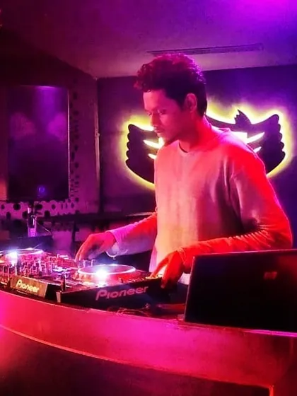 Here I am at the decks, surrounded by the purple and red lights of a nightclub. The atmosphere is everything, and I love matching my music to the visual energy of the space.