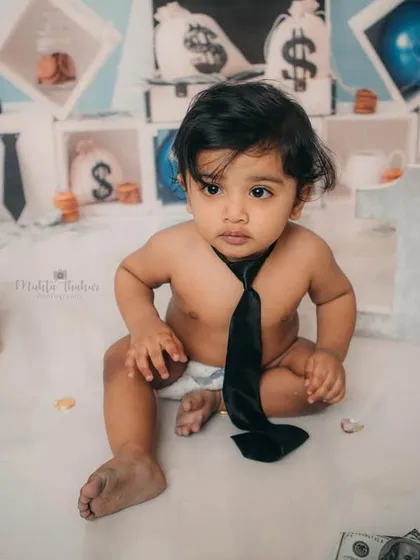 This little boss is taking a moment to think. Themed cake smashes are a fantastic way to capture your baby's personality at one year old.