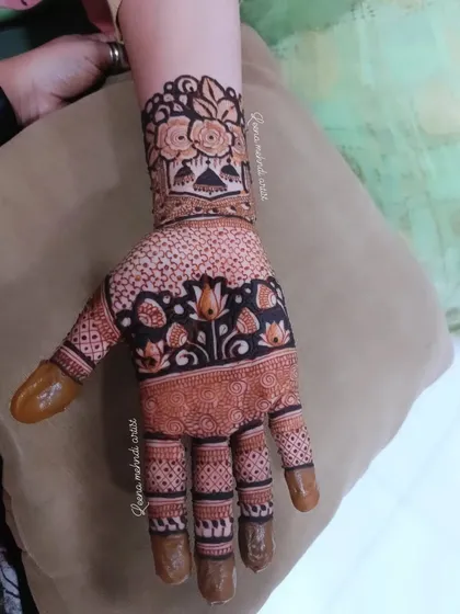 A single-hand view of a lovely guest mehndi design. The pattern includes lotuses, a dotted grid, and a floral wristband, offering a full look that can be applied quickly.