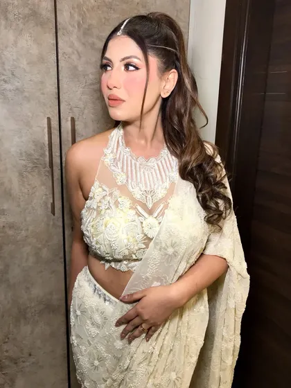The side profile shows off her high ponytail and the delicate placement of the pearl maang tikka.