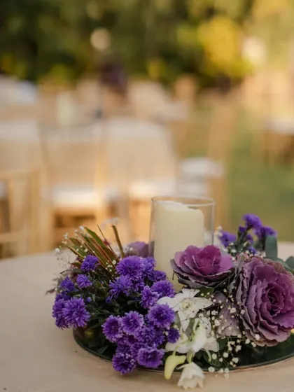 A closer look at the striking purple and white floral centerpiece. These small details are essential for tying the entire decor theme together and adding a touch of sophistication to each table.