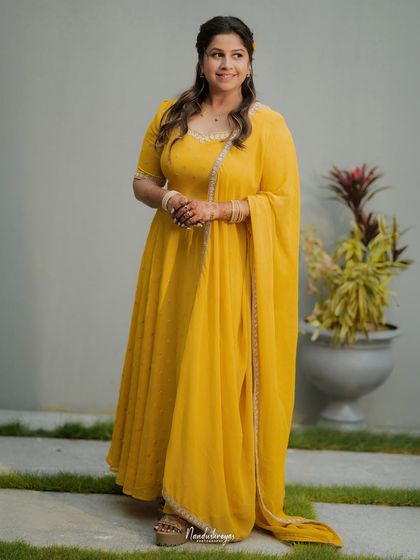 A full-length portrait of the bride in her beautiful yellow anarkali, showcasing her complete Haldi look with grace and elegance.