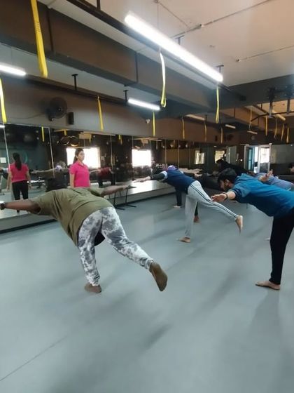 Students practice single-leg balance exercises, a key component of functional fitness and injury prevention that we teach.