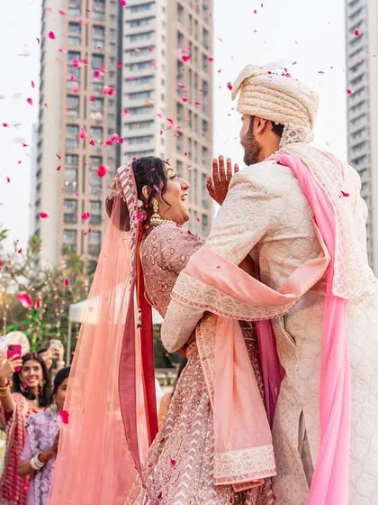 A candid and adorable moment where the bride trips slightly during the varmala, and the groom instantly has her back. It's a sweet glimpse into a future of supporting each other.