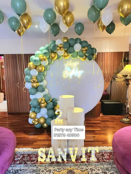 A sage green, gold, and white balloon arch for Sanvit's 2nd birthday.