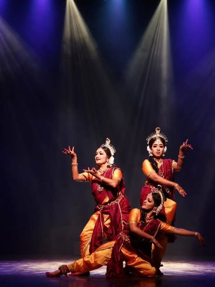 A beautifully synchronized moment from "Shrishti Stithi Laya". The three dancers move as one, their forms highlighted by dramatic spotlights, embodying the principles of creation, preservation, and dissolution.