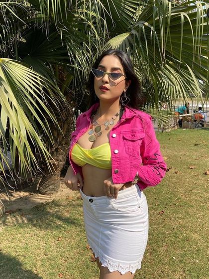 Another look from the 'Haan Karde' music video. The combination of the bright pink jacket, neon top, and cat-eye sunglasses creates a bold and trendy aesthetic.