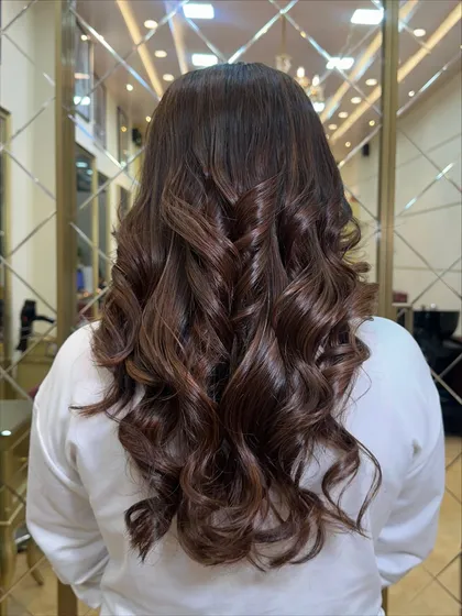 Another angle of the rich, curly hazelnut mocha style. This color is perfect for any season and adds a touch of effortless shine.