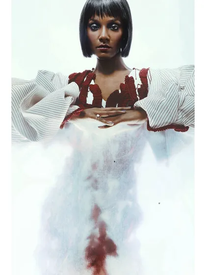 A variation of the previous shot, where the model's form is more defined. The styling with the puffy sleeves and the red embroidered top creates a strong shape even through the hazy filter.