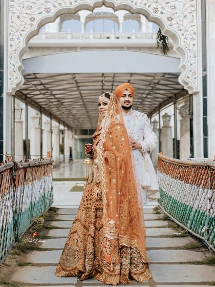 A striking portrait of the Sikh couple on a bridge, the Indian flag colors painted on the side adding a patriotic touch.