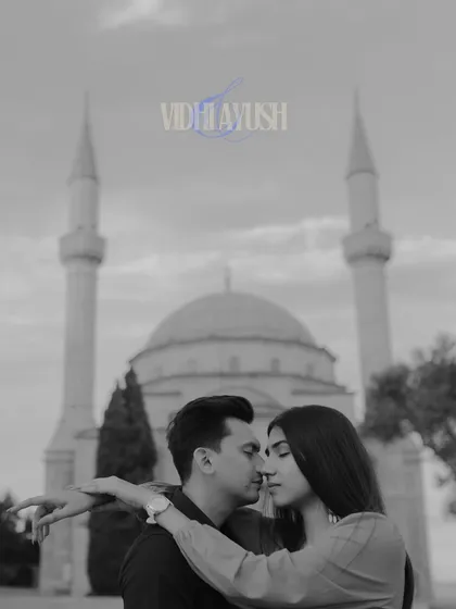 A romantic black and white pre-wedding photo in front of a mosque in Baku. The silhouette against the historic architecture creates a timeless and soulful image, focusing on their intimate connection.