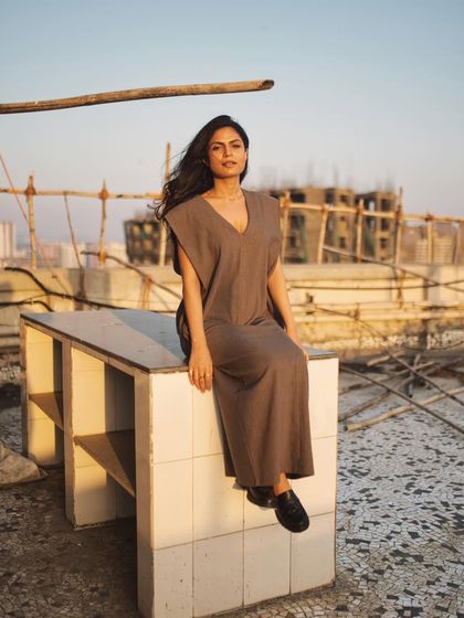 A wider shot from the rooftop, showing the urban background and capturing a serene, seated pose.