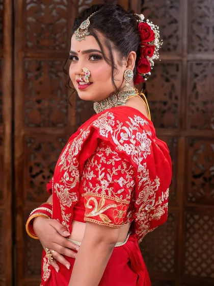 A side profile showcasing the complete look, from the elegant hairstyle to the beautifully embroidered red blouse.