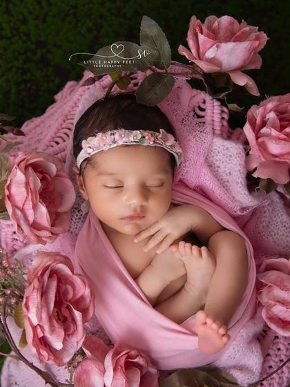 A bed of pink roses. This classic, romantic setup is perfect for a baby girl, creating a portrait that is both sweet and timeless.