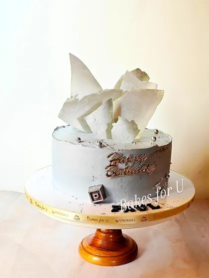 This modern birthday cake is a whole wheat date and walnut cake. I gave it a contemporary look with a grey buttercream finish and abstract white chocolate shards.