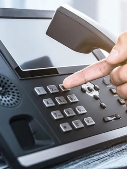We provide modern enterprise telephony systems that form the backbone of your business communication. This close-up shows a user interacting with an IP-based phone, highlighting the intuitive interface and advanced features that streamline daily call management and internal connectivity.