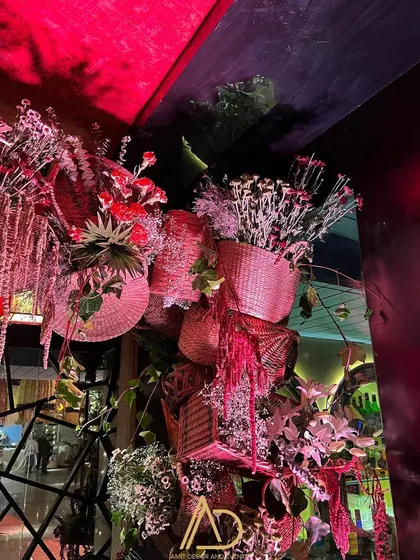 A creative floral installation using woven baskets and dried flowers, adding texture and a rustic touch to a corner of the venue.