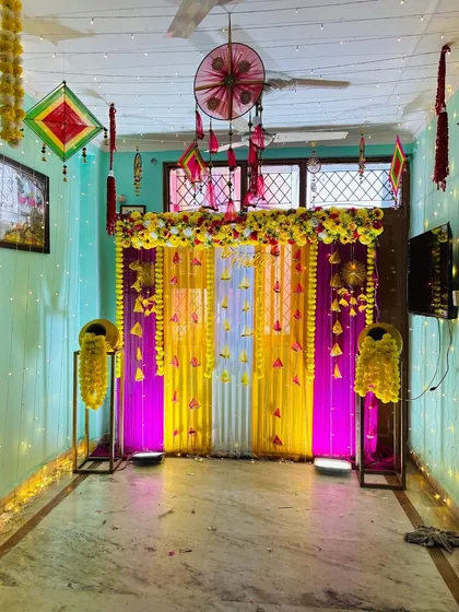 Even in a smaller home, I can set up a beautiful and complete Haldi ceremony backdrop. This design uses bright fabric drapes, marigold flower arrangements, and LED uplighting to transform any corner of your house into a festive space.