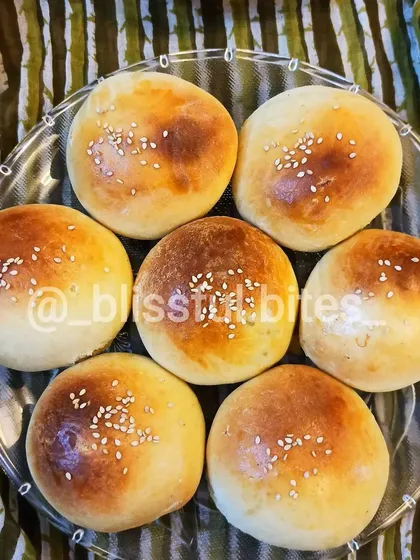 My homemade buns, fresh from the oven. These soft, golden buns, topped with sesame seeds, are the foundation of my delicious burgers and can be filled with mince or chicken.
