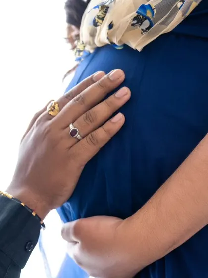 A close-up focusing on the hands on the baby bump, a simple yet powerful image of connection and anticipation.