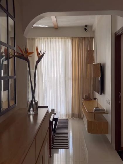 This home was inspired by the idea of a "cozy modern farmhouse." This view from the entryway shows how arches and natural materials like wood and cane create a warm, inviting path into the living space.