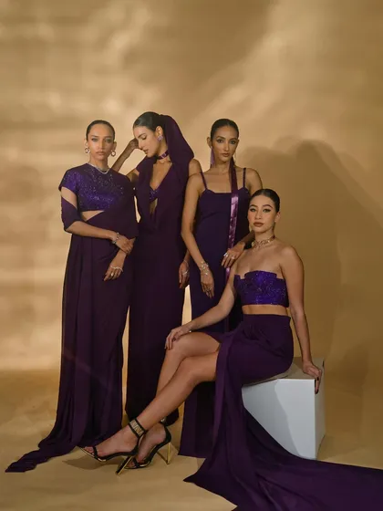 A group shot presenting the 'Amethyst Edit' by Nikhil Thampi. The composition arranges the models to display four different purple outfits, showing the collection's range and harmony.