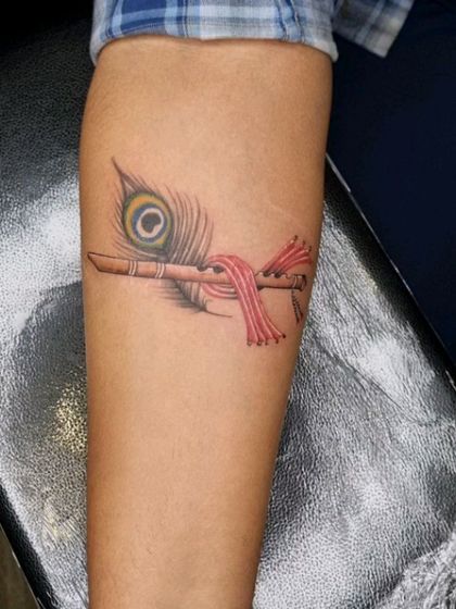 The finished Krishna's flute tattoo, successfully covering the scar with a piece rich in cultural symbolism.