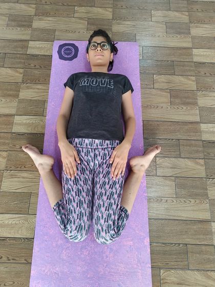 This student is in Supta Virasana (Reclining Hero Pose). It's a deep stretch for the quadriceps and hip flexors, and also helps to improve digestion.