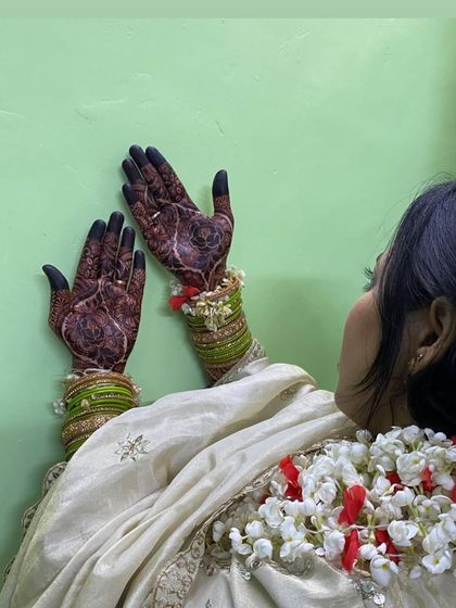 A candid shot of a bride showing her beautiful dark henna stain. The black-tipped fingers are a traditional element I love.