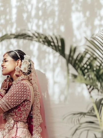 A serene side-profile of the bride. This quiet, contemplative shot highlights her elegant hairstyle and the beautiful floral arrangement in her hair.