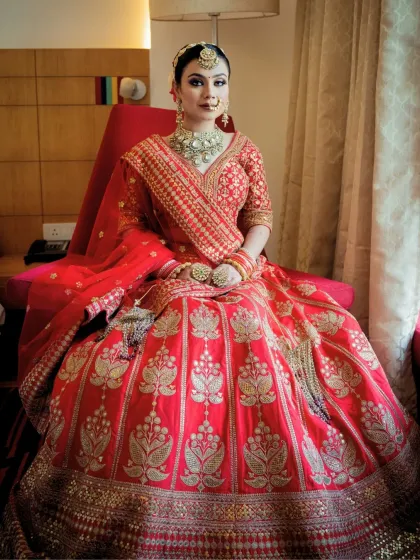 A full-length shot of the bride in her majestic red lehenga. The shimmery eye makeup and glowing base create a head-turning look that is both bold and beautiful.