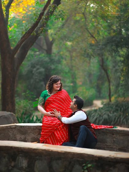 A beautiful outdoor session featuring a traditional red leheriya saree. The partner's adoring gaze makes this a very sweet and intimate moment.