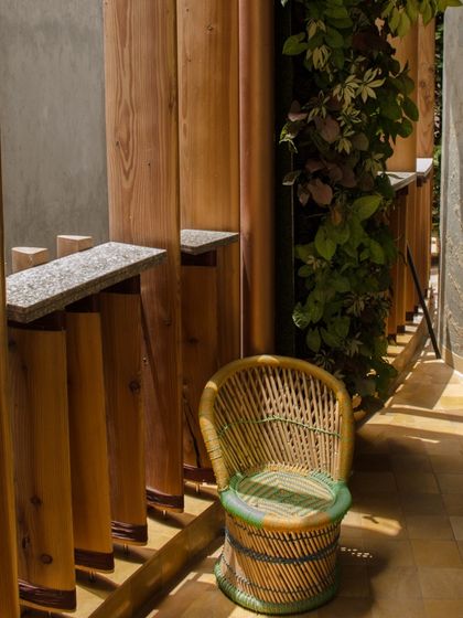 A cozy corner on one of the Outré House balconies, demonstrating how even small spaces can become tranquil retreats through thoughtful design and material choices.