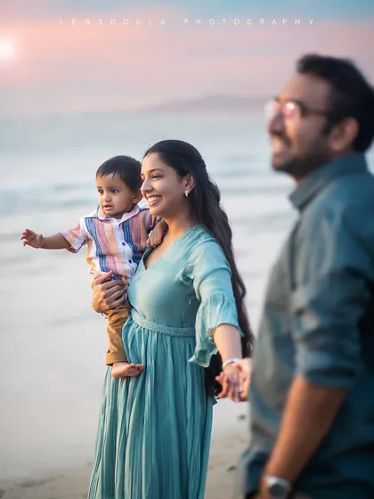 A beautiful candid moment of a family walking on the beach. The focus on the mother and child, with the father slightly blurred, creates a lovely sense of depth.