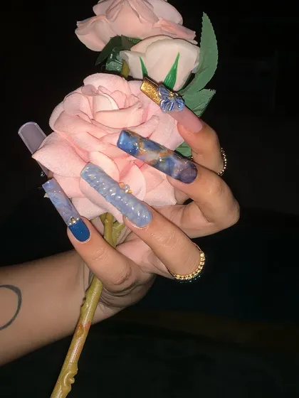 An elaborate water-themed nail art design with long extensions, marbling, and 3D embellishments.