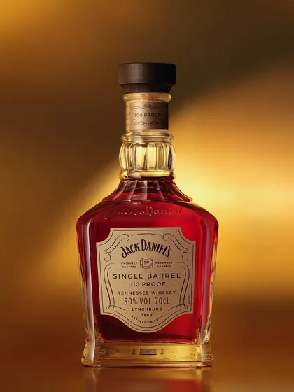 A single-shot setup for this beautiful Jack Daniel's Single Barrel. The warm, golden gradient background makes the reddish whiskey glow. This is all about capturing the premium feel with clean, precise lighting.