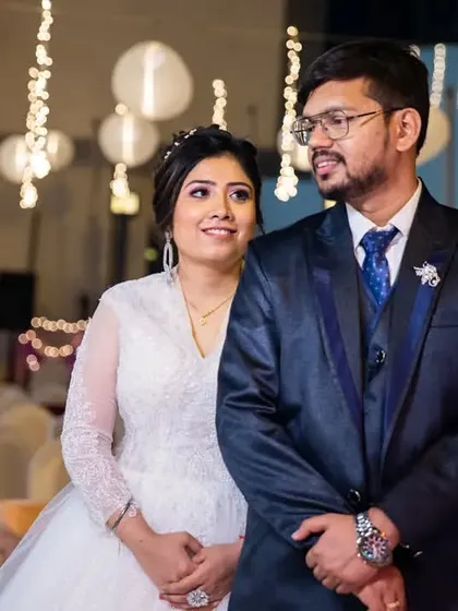 A classic portrait of the couple at their reception, with beautiful bokeh from the hanging lights creating a magical atmosphere.