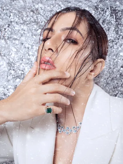 A glamorous beauty shot from a winter-themed editorial. The "snow" effect and the model's wet-look hair create a high-fashion, dramatic image.