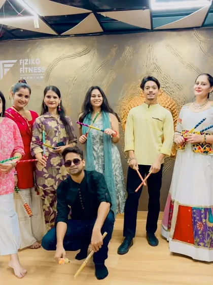 A group photo from a Dandiya practice session at a fitness studio. Dressed in traditional attire, the participants are all set for a night of festive dancing.