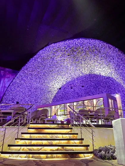 A unique, igloo-like structure serves as a cozy and stylish dining pod within the larger event space, offering guests a one-of-a-kind experience.