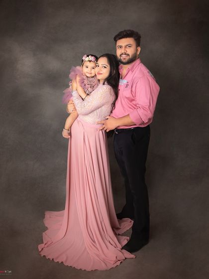 A classic family portrait for a first birthday celebration. The coordinated pink outfits make for a sweet and cohesive look.