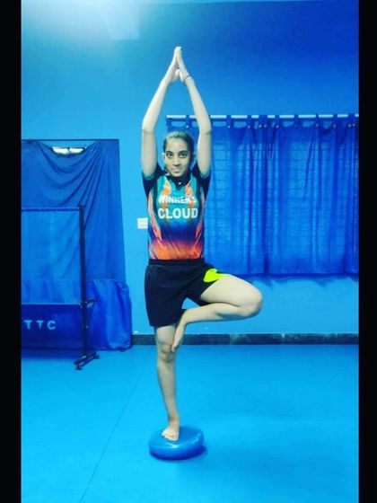 Balance and stability are crucial for table tennis. A player holds the tree pose on a balance disc, an exercise we use to enhance core stability and concentration.