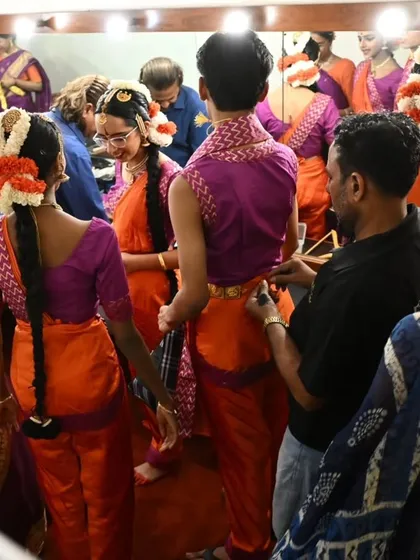 The green room before a show is a hive of activity. Dancers help each other with costumes and jewelry, creating a wonderful atmosphere of camaraderie and shared purpose.